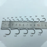 Set of fishing hooks with size markings on a ruler against a light gray background