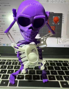 Purple skeleton figurine on a laptop keyboard with a computer screen in the background