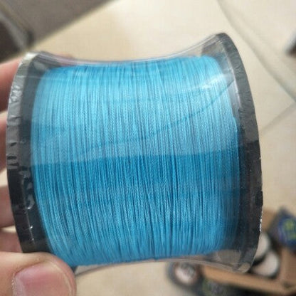 Spool of blue thread held by a hand on a blurred background