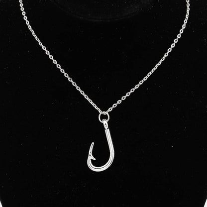 Silver fish hook pendant on a chain against a black background