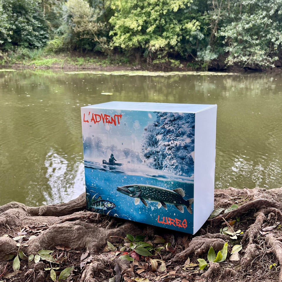 Fishing-themed box with 'Ládvent' and 'Lurea' branding by a pond.