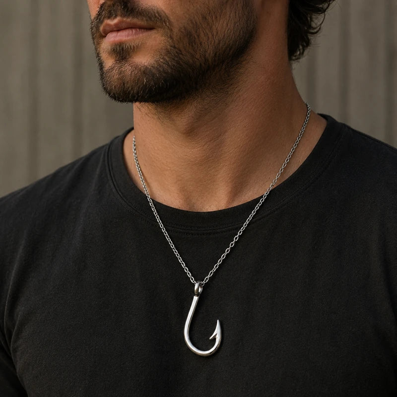 Man wearing a black shirt with a silver fish hook necklace.