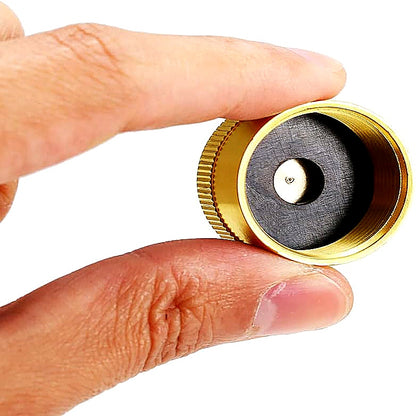 Hand holding a small mechanical component with gold casing and black interior.