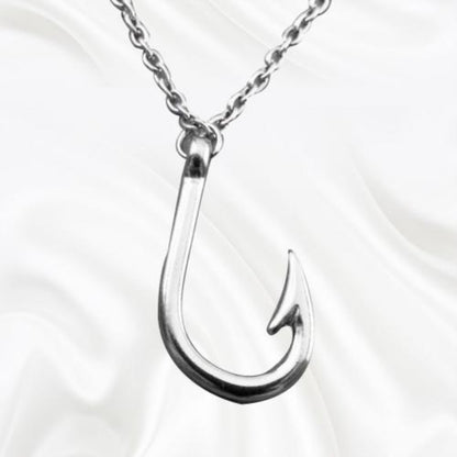 Silver fishing hook pendant on a chain against a white background